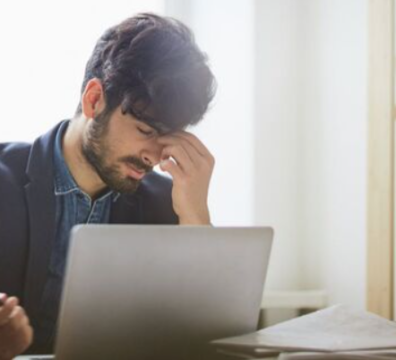 一位年輕男性在電腦前揉眼睛，感到視覺疲勞與不適，象徵用眼過度與需要保護眼睛。