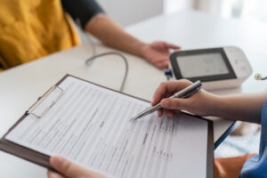 醫護人員正在協助熟齡者填寫健康問診單，並準備進行血壓等基礎檢查