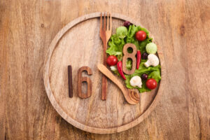 木盤上用數字「16」和「8」搭配餐具與蔬菜呈現出168間歇性斷食的概念。