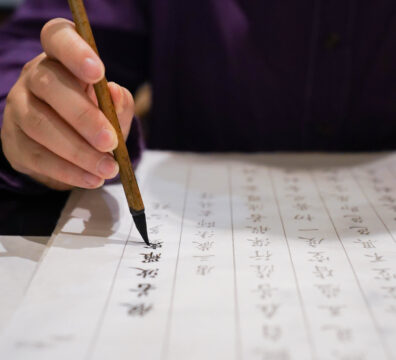 手握毛筆專心書寫書法，展現靜心與專注的書寫狀態