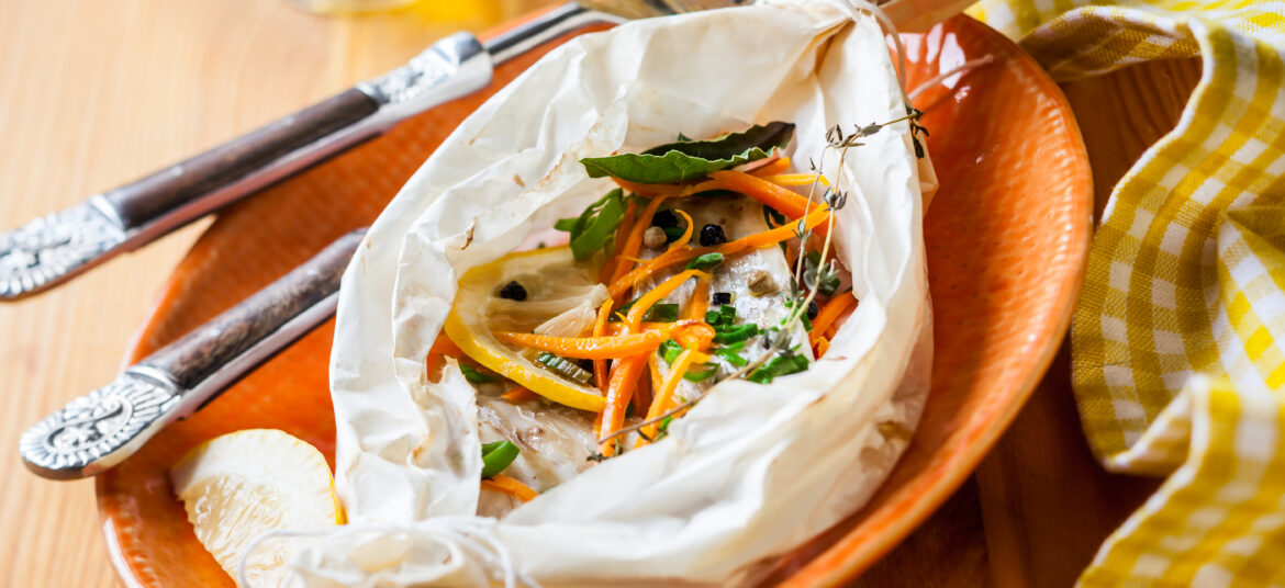 紙包魚製作過程,將魚與櫛瓜、紅蘿蔔與番茄放入料理紙中準備烘烤