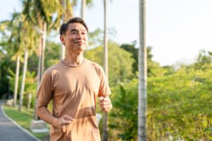 一名中年男性穿著輕便上衣，在戶外步道上自然快走，呈現健康、有活力的步行狀態。